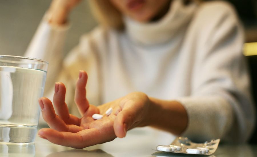 Photo of a woman holding pills