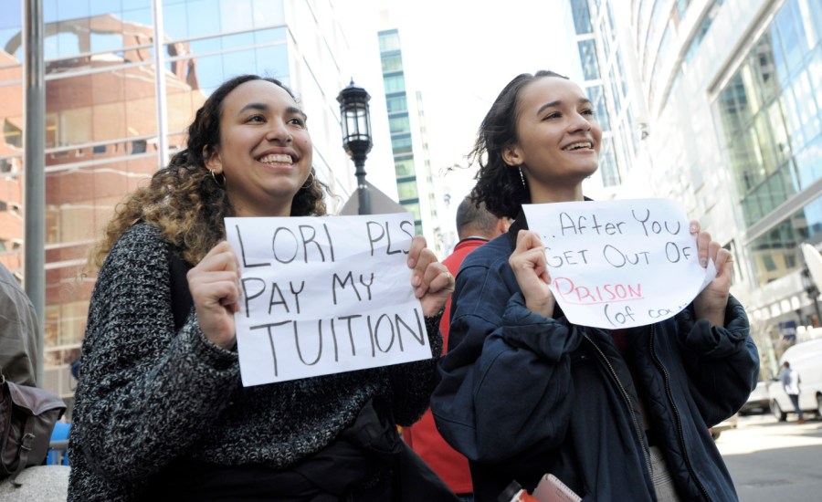 Young people hold up signs during Felicity Huffman's trial