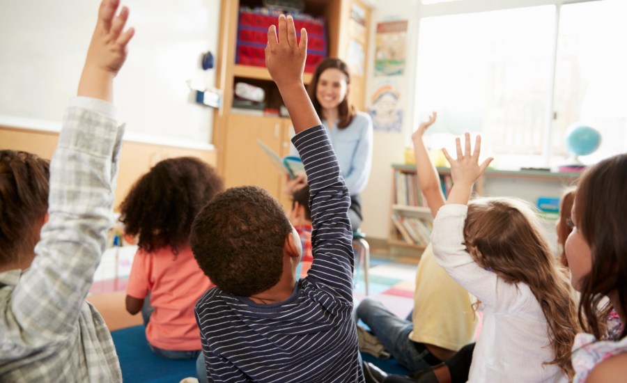 Image: Kids raise their hands in a classroom