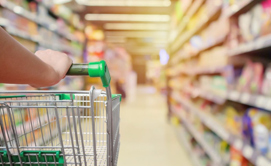 a person pushes a grocery cart in a grocery store