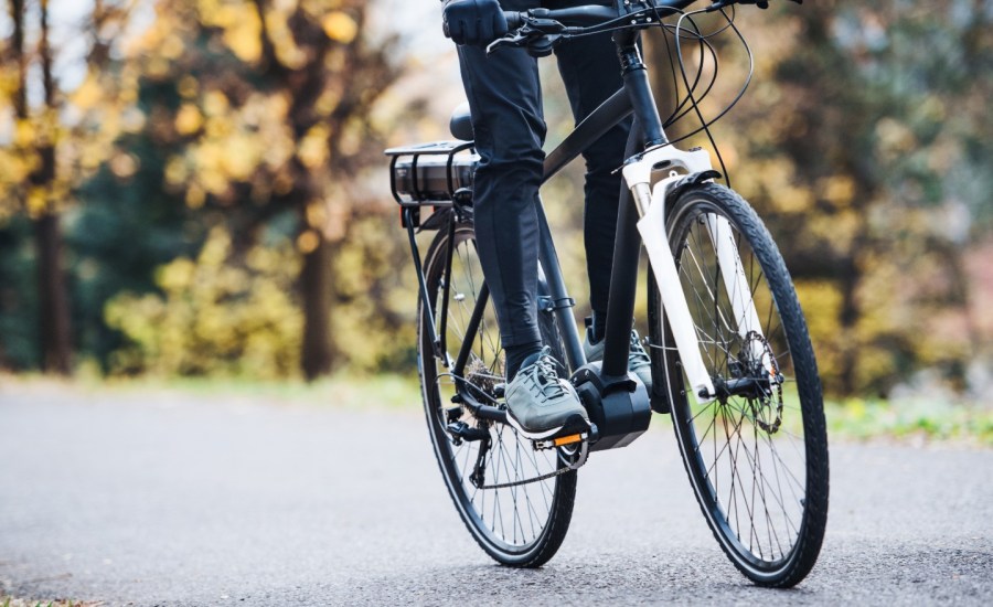 a person rides an e-bike on a trail in a park