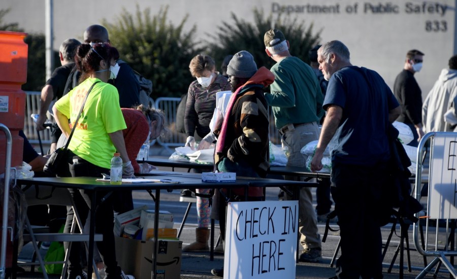 People arrive at a temporary homeless shelter set up in a parking lot at Cashman Center in Las Vegas, Nevada