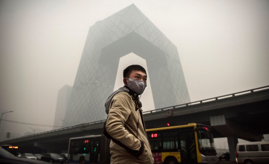 man wears a mask in a polluted city in China