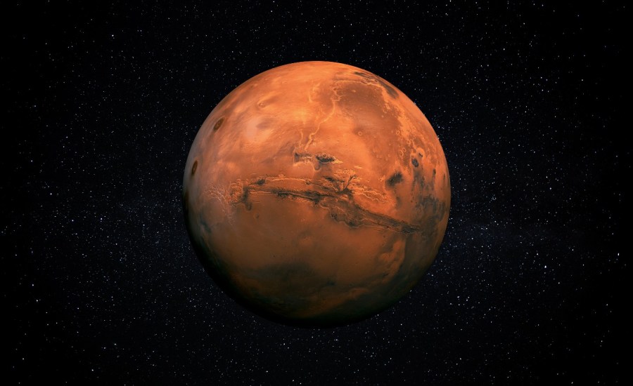 an image of mars, the red planet, in space, with topography enhanced in gray and stars