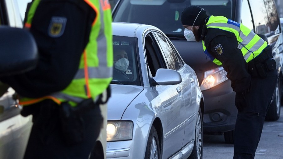 German police check vehicles at border crossing with Austria.