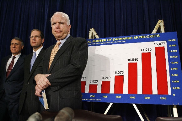 The late Sen. John McCain stands in front of chart during discussion of earmarks