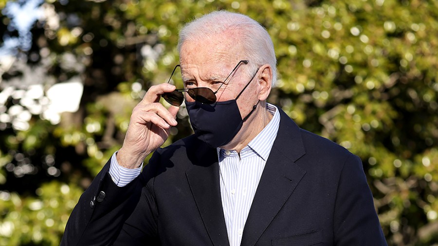 President Biden removes his aviators as he returns to the White House