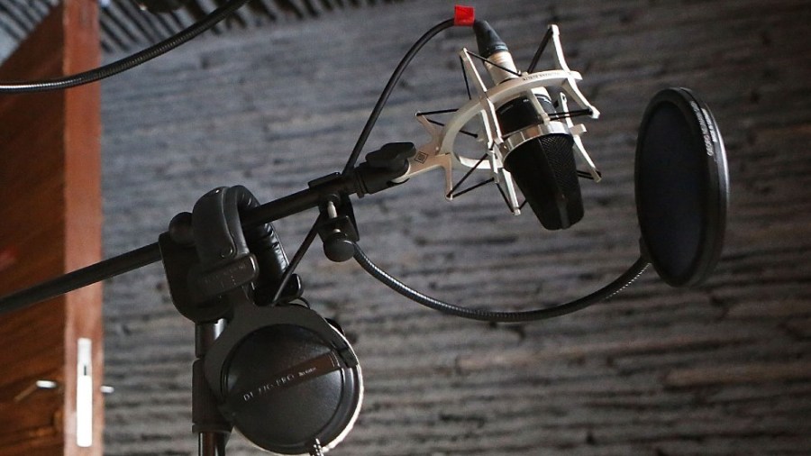 A microphone and headphones are seen in a radio studio