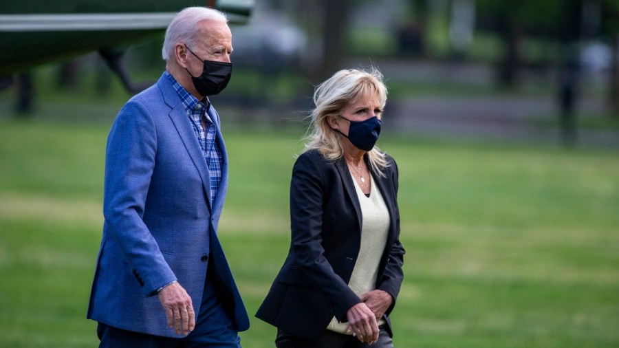 President Biden and first lady Jill Biden walk across the White House lawn