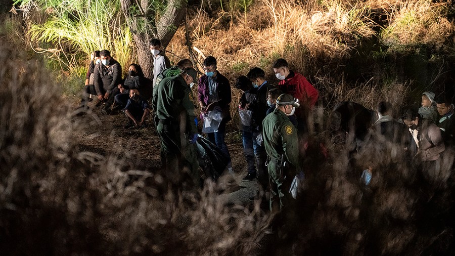 Asylum-seeking migrants' families wait to be transported by the U.S. Border Patrol after crossing the Rio Grande river into the United States from Mexico on April 23