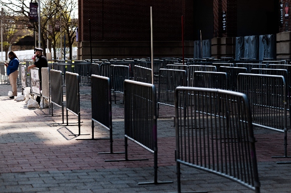 A Baltimore Police Officer and a healthcare worker stand at the empty entrance to mass vaccination site