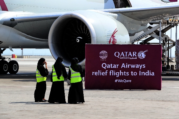 Workers load medical aid to be flown in a three-flight cargo Qatar Airways aircraft convoy directly to destinations in India