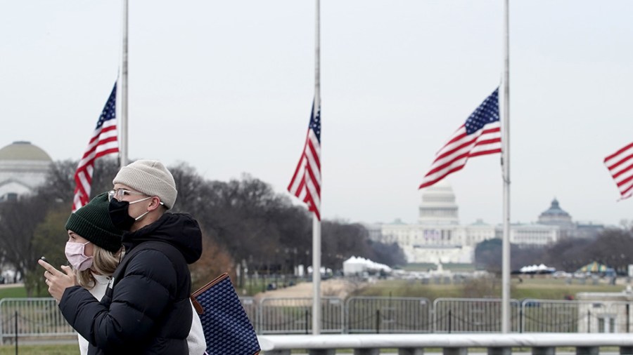 Tourists wearing masks stand near the Capitol in Washington, D.C.