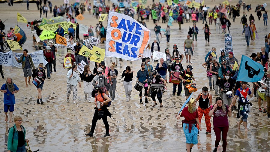 Activists take part in an Extinction Rebellion climate change protest march on the beach in St Ives, Cornwall on June 11 on the first day of the G7 summit