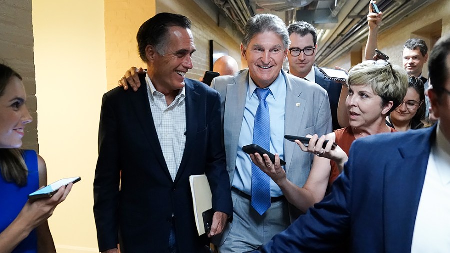 Sens. Mitt Romney (R-Utah) and Joe Manchin (D-W.Va.) leave a bipartisan meeting to discuss an infrastructure deal on June 21