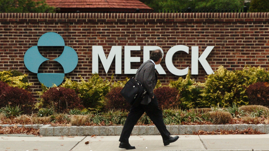 A man walks by a sign at a Merck plant in Rahway, N.J.