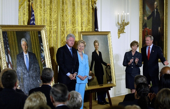 Former US President Bill Clinton and Senator Hillary Clinton stand by their official White House portraits during the unveiling event