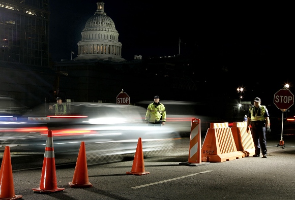 U.S. Capitol Police officers check vehicles before they drive past the U.S. Capitol