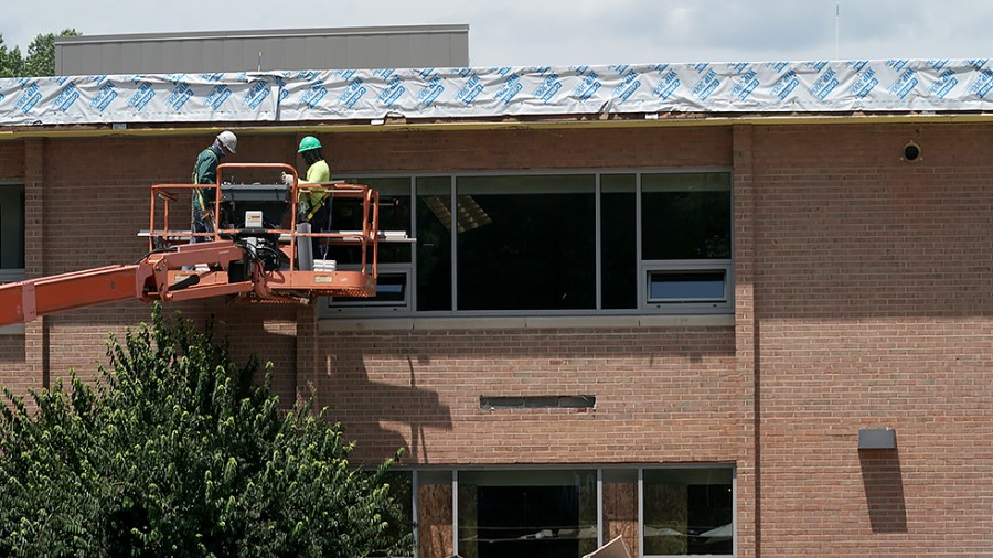 Construction workers attend to Oakton High School in Oakton, Va., on June 2