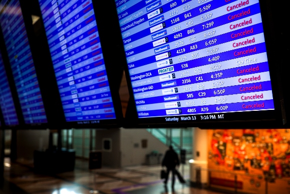 An airport display lists flight cancellations