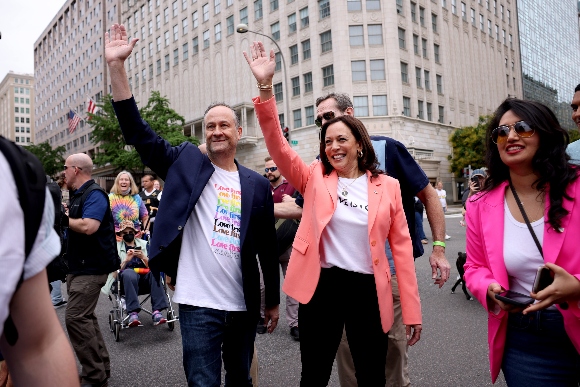 Vice President Kamala Harris and husband Doug Emhoff wave as they join marchers for the Capital Pride Parade