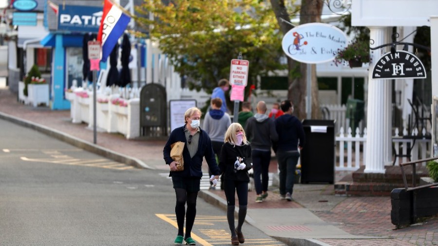 Pedestrians walk down Commercial Street in Provincetown, Mass.