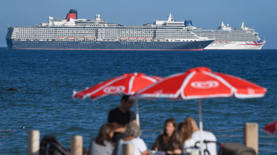 Cruise ships the Queen Elizabeth and the Britannia are seen anchored in the English Channel off the Dorset coast