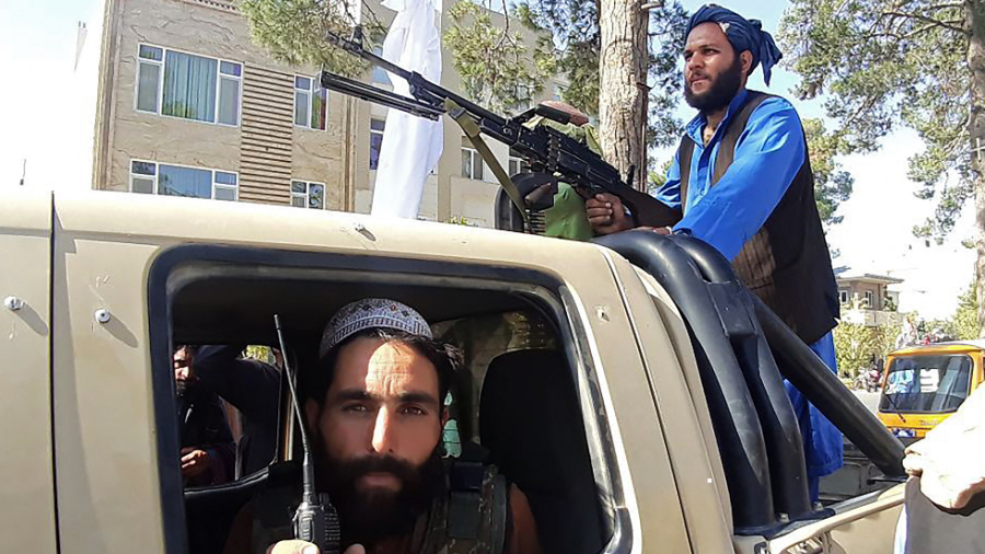 Taliban fighters are seen in a vehicle along the roadside in Herat, Afghanistan's third biggest city, after government forces pulled out the day before