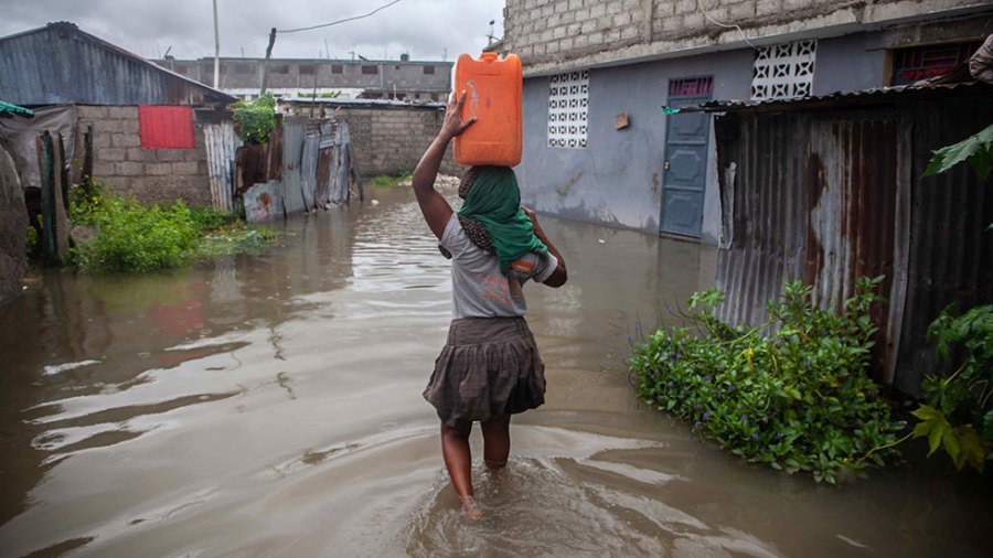 A woman wades through water in Haiti after Tropical Depression Grace