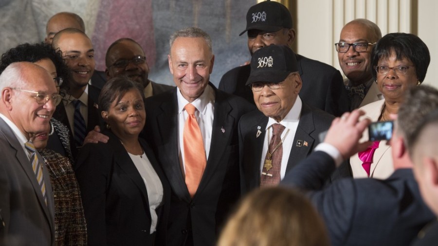 US Senator Chuck Schumer, Democrat of New York, poses for photos with veterans of the 369th Infantry Regiment, nicknamed the "Harlem Hellfighters"