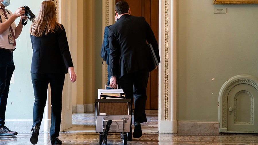 Staffers wheel a copy of the bipartisan infrastructure legislation towards the suite of Majority Leader Charles Schumer (D-N.Y.) on Monday, August 2, 2021.