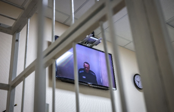 Jailed Kremlin critic Alexei Navalny appears on screen via a video link from prison