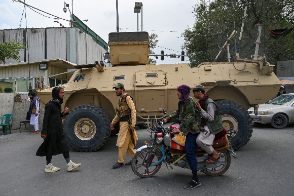 Taliban fighters patrol along a street in Kabul