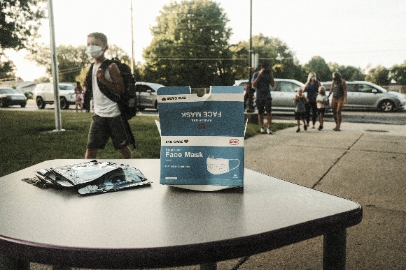 Face masks sit on a table outside of Schoolcraft Elementary for students and parents to wear