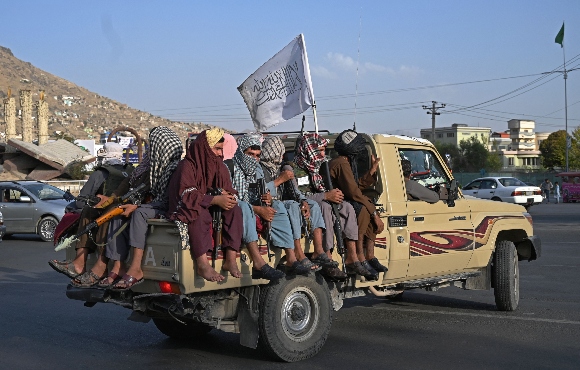 Taliban fighters in a vehicle patrol the streets of Kabul