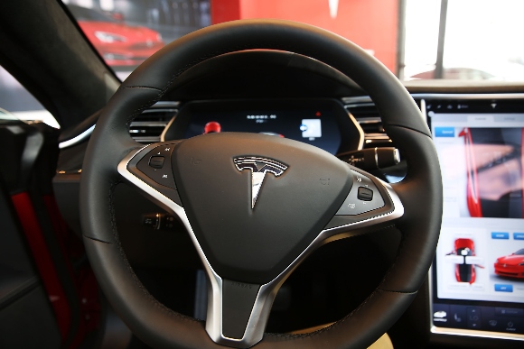 The Tesla logo on a steering wheel