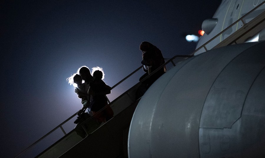 Passengers evacuated from Afghanistan disembark from a British Royal Air Force plane in the dark