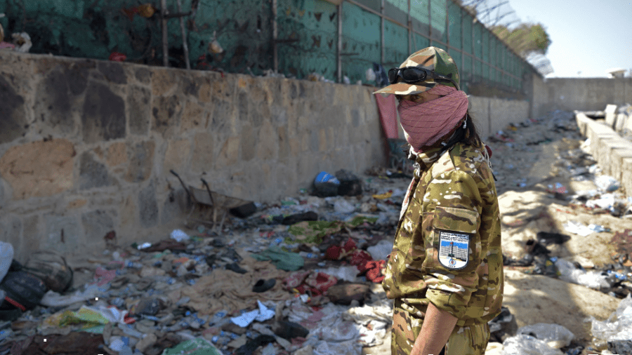 A Taliban fighter stands guard outside the Kabul airport