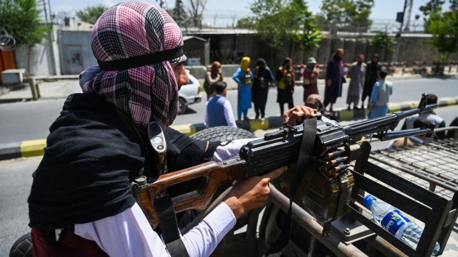 An armed Taliban fighter rides through Kabul