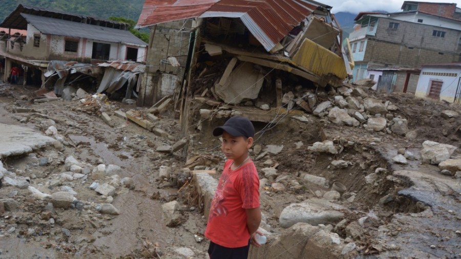 A child stands in front of houses destroyed by a mudslide in the town of Tovar in the state of Merida, Venezuela