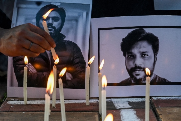 Candles are placed by journalists next to the portrait of Reuters journalist Danish Siddiqui