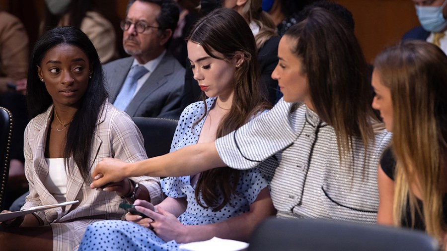 U.S. Olympic gymnasts Simone Biles holds hands with Aly Raisman and Maggie Nichols before a Senate Judiciary hearing about the Inspector General's report on the FBI handling of the Larry Nassar investigation on September 15, 2021.