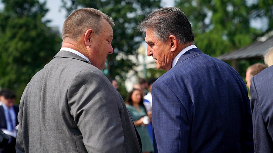 Sen. Jon Tester (D-Mont.) speaks with Sen. Joe Manchin (D-W.Va.) during a press conference on Friday, July 30, 2021 to discuss the bipartisan infrastructure deal with members of the Problem Solvers Caucus.