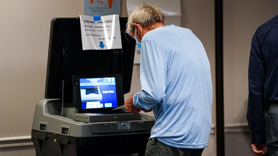 A voter casts his ballot during early voting at the Fairfax County Government Center in Fairfax, Va., on Friday, September 17, 2021.