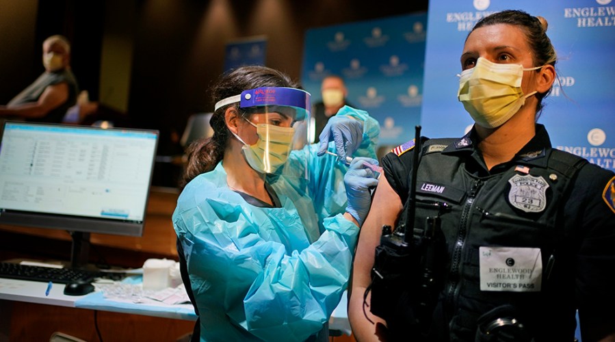 A female police officer gets a COVID-19 vaccine