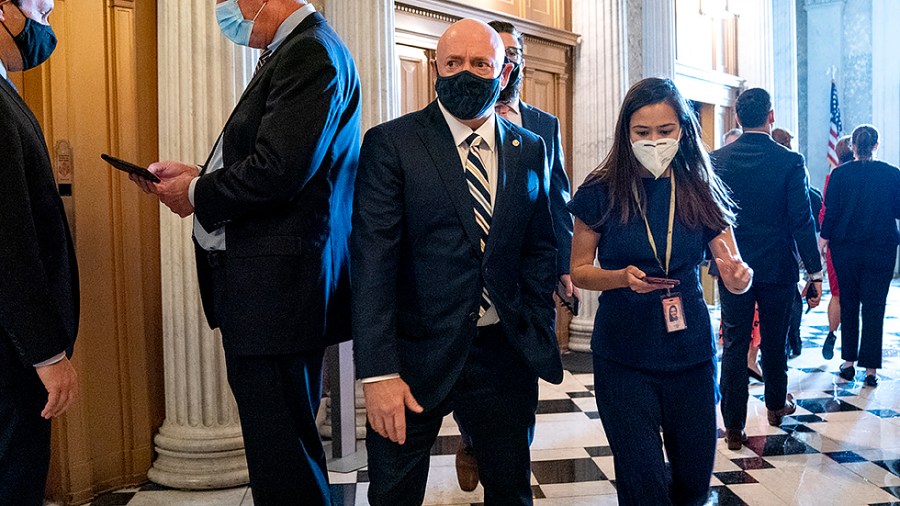 Sen. Mark Kelly (D-Ariz.) speaks to a reporter as he arrives to the Senate Chamber for a nomination vote on Tuesday, October 5, 2021.