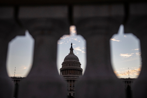 The sun rises behind the U.S. Capitol Building