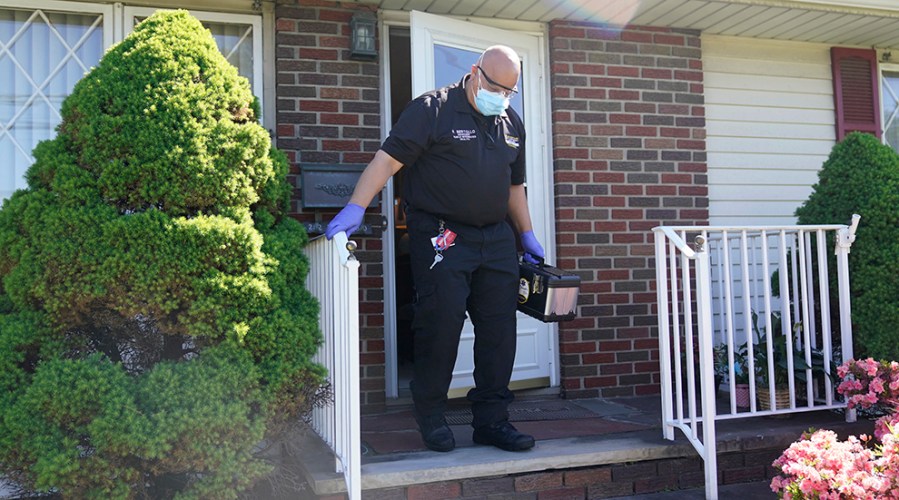 A paramedic walks out of a home