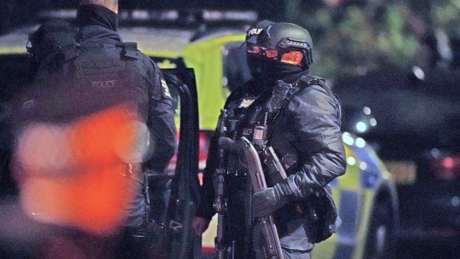 An armed police officer holds a breaching shotgun after an explosion at the Liverpool Women's Hospital in Liverpool, England