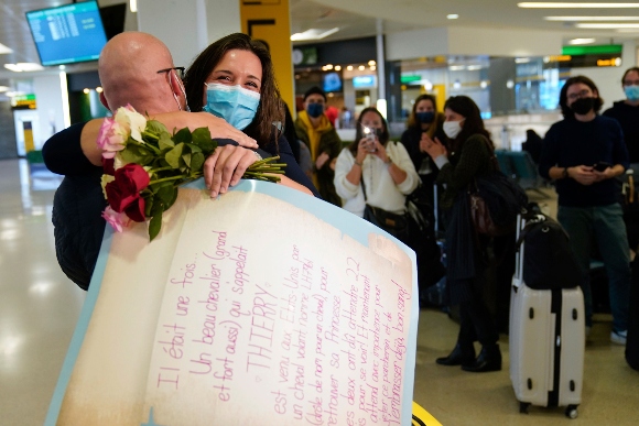 People applaud and take pictures as MaKensi Kastl greets her boyfriend, Thierry Coudassot, after he arrived from France at Newark Liberty International Airport